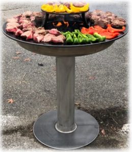 Brasero/plancha ou barbecue, ce brasero est en inox pour le pied et en acier pour l'anneau de cuisson d'un diamètre de 650mm Chaleur et ambiance Diffuse une chaleur agréable autour du foyer, idéale pour prolonger les soirées en extérieur. Crée une ambiance chaleureuse et conviviale, bien plus vivante qu’un simple barbecue. 🍳 2. Cuisson polyvalente et saine La plaque plancha permet de cuire viandes, poissons, légumes, œufs ou fruits sans flamme directe. Cuisson homogène, peu de fumée, et moins de graisses brûlées qu’au barbecue classique. Possibilité de cuire plusieurs aliments en même temps à différentes températures selon la zone de la plaque. 👨‍👩‍👧‍👦 3. Convivialité maximale Les convives peuvent se rassembler tout autour et participer à la cuisson. Le cuisinier ne tourne plus le dos aux invités : tout se fait au centre de la table sociale. Utilisable aussi bien en été qu’en mi-saison ou en hiver grâce à la chaleur dégagée. La plaque se nettoie facilement à chaud avec une spatule et un peu d’huile.